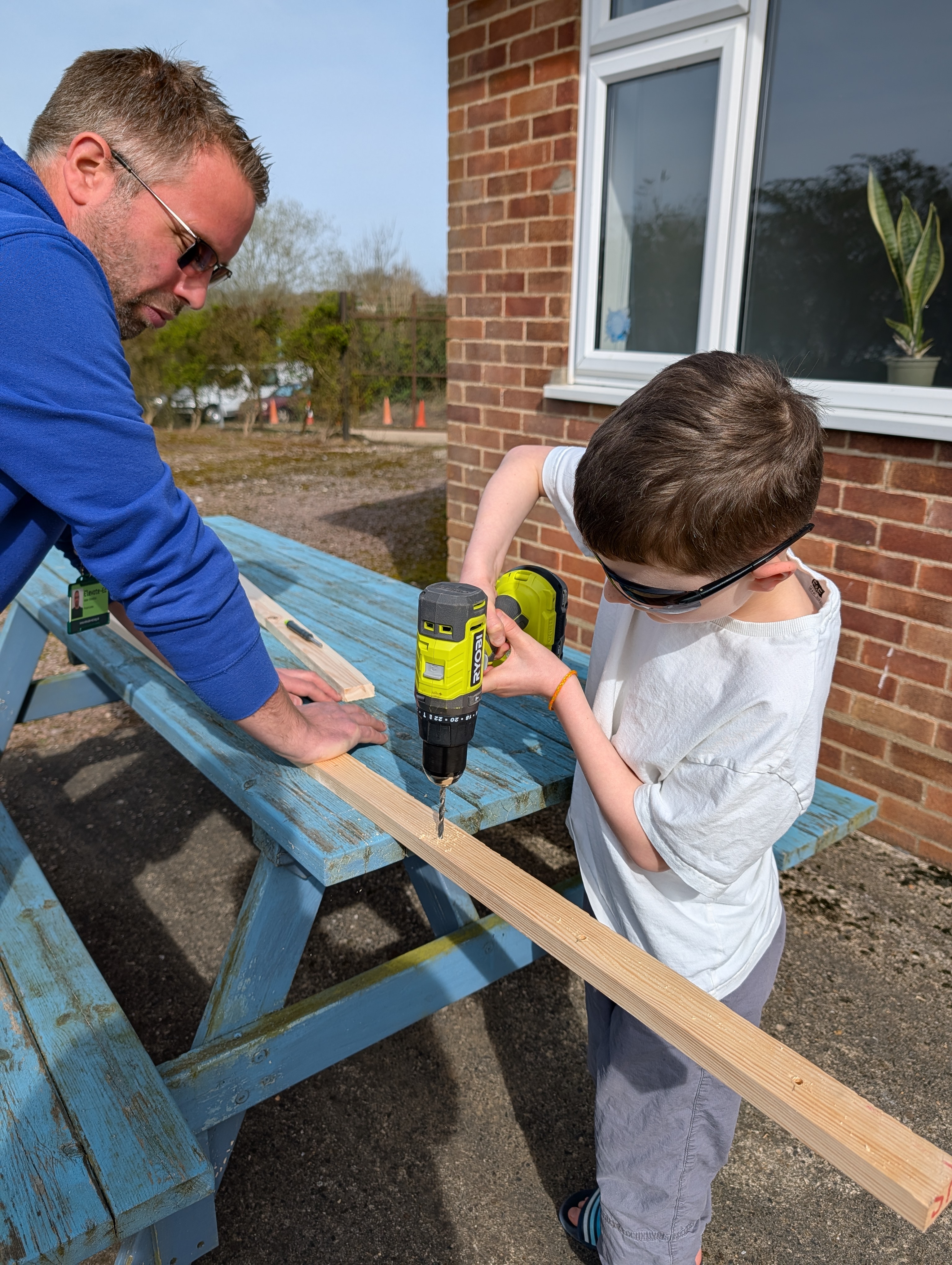 Practitioner supporting a learner with outdoor woodwork